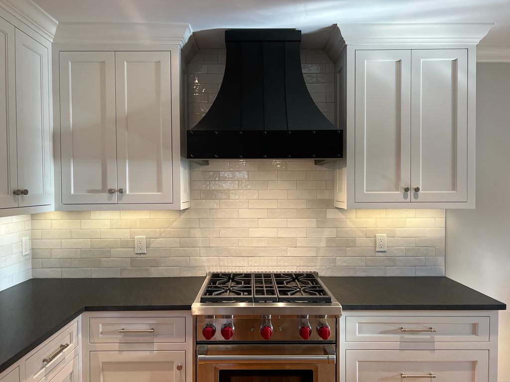 Sleek and sophisticated french kitchen design white kitchen cabinets brick backsplash, all complemented by a modern range hood