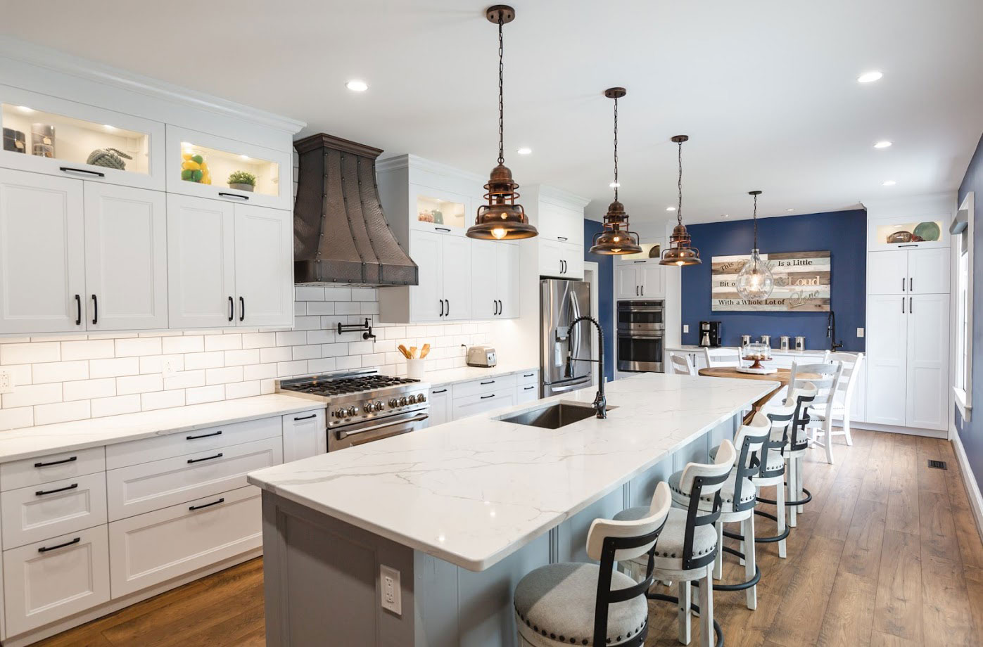 Extraordinary coastal kitchen design featuring wood kitchen cabinets, white kitchen countertops, brick backsplash is enhanced by a sleek range hood