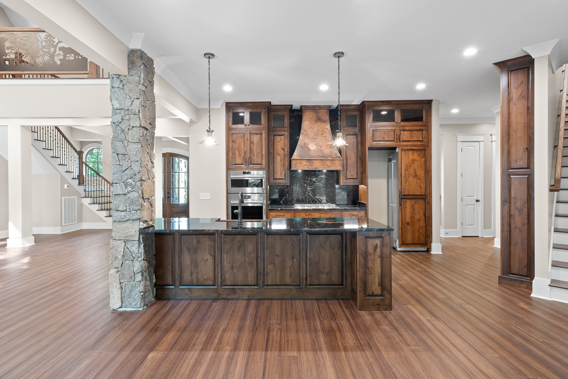 Copper sleek black range hood, complemented by elegant wood kitchen cabinets and stunning marble backsplash