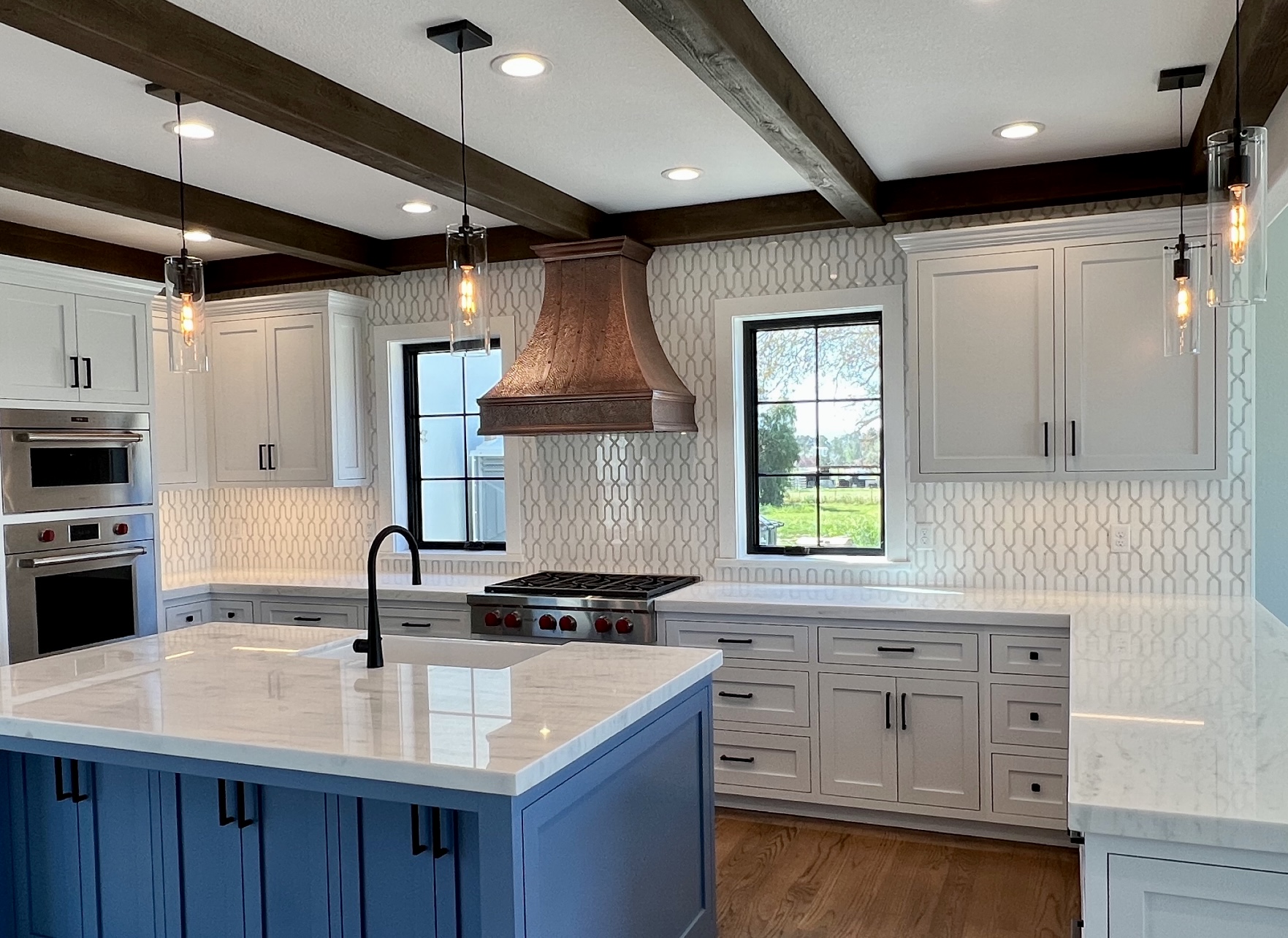 Cottage kitchen design with white kitchen cabinets, elegant marble kitchen countertops, a beautiful marble backsplash, and explore unique kitchen sink idea