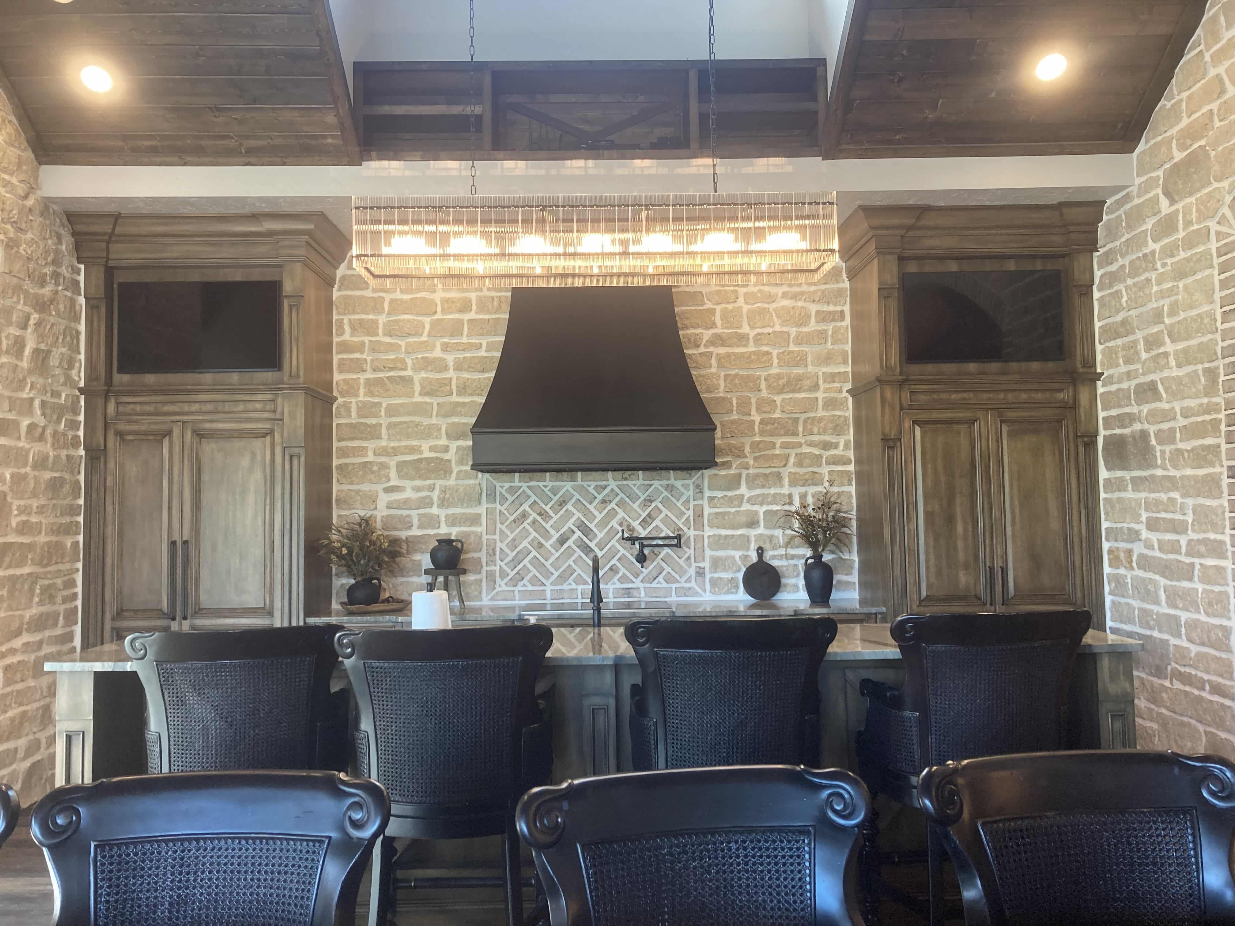 CopperSmith Signature SX5 Wall Mount Black Enamel Smooth Range Hood with Straps in a Country style kitchen with stone backsplash marble countertops and wood cabinets