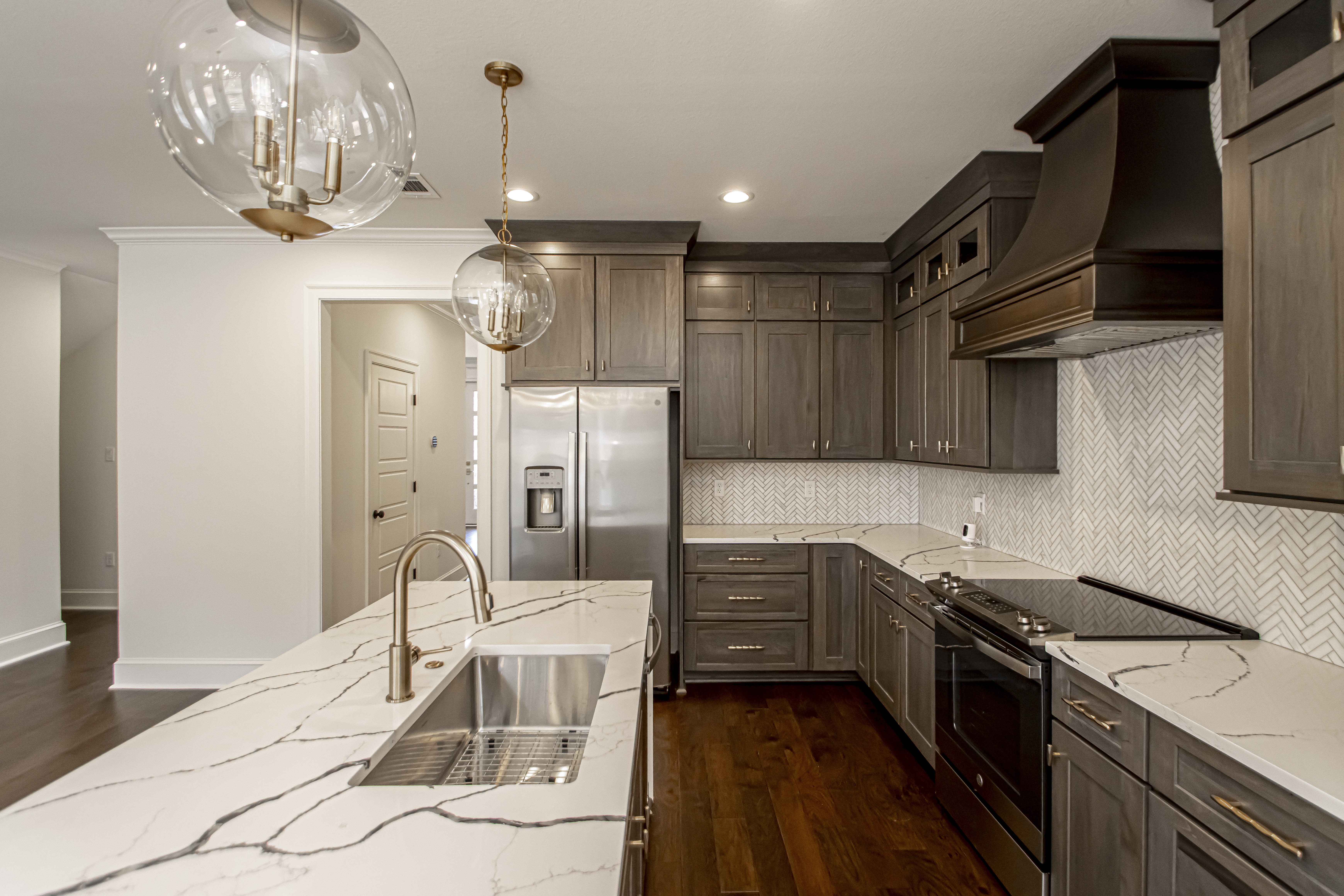 Incorporating range hood kitchen remodeling, grey kitchen cabinets complemented by elegant marble kitchen countertops