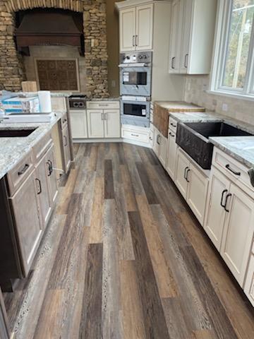 Captivating kitchen design idea highlighting a range of hood styles, white kitchen cabinets,marble kitchen countertops, charming brick backsplash