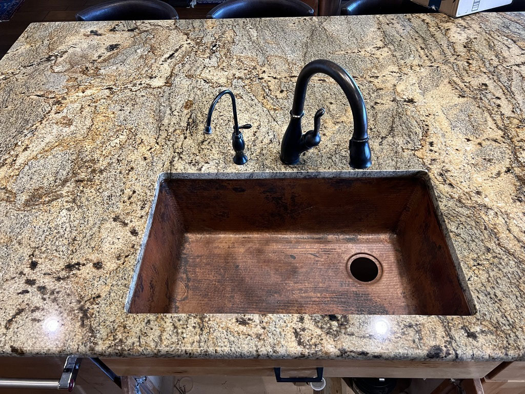 Copper sink in a kitchen with granite countertop World CopperSmith